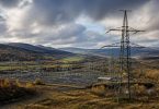 Tralicci e infrastrutture elettriche collegano diverse aree di un territorio europeo.