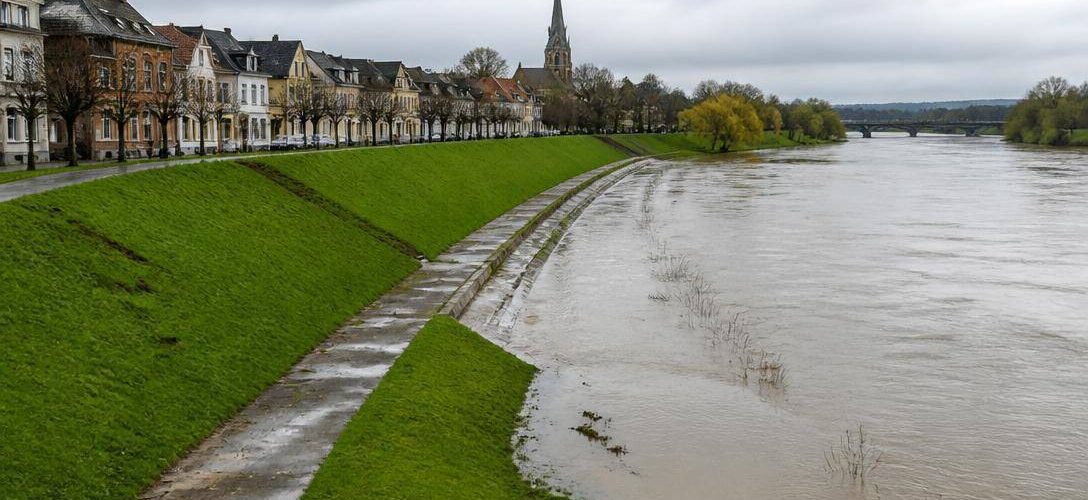 Centro abitato europeo protetto da argini e infrastrutture lungo un fiume