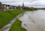 Centro abitato europeo protetto da argini e infrastrutture lungo un fiume
