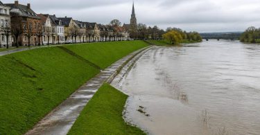Centro abitato europeo protetto da argini e infrastrutture lungo un fiume