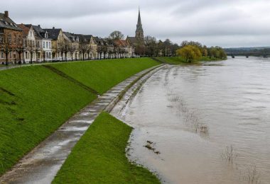 Centro abitato europeo protetto da argini e infrastrutture lungo un fiume