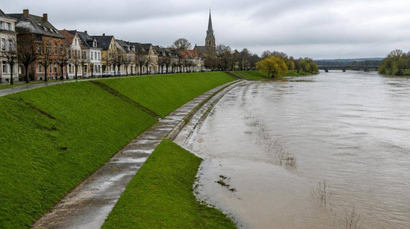 Centro abitato europeo protetto da argini e infrastrutture lungo un fiume