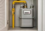 Persona controlla il termostato del riscaldamento e le spese domestiche.