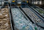 Operatori lavorano in un impianto di selezione dei materiali destinati al recupero.