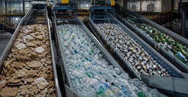 Operatori lavorano in un impianto di selezione dei materiali destinati al recupero.